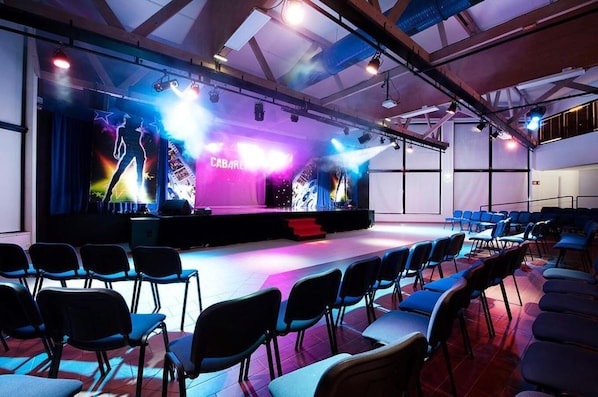 A stage with a "CABARET" sign, rows of chairs, and stage lighting. - Village Club Kerlannic (Arzon)