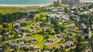An aerial view of a coastal resort with multiple buildings, a swimming pool, and a beach. - Village Club Kerlannic (Arzon)