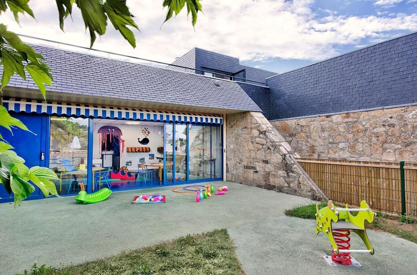 Ein Spielbereich für Kinder mit Rutsche, Schaukeln und einer Kletterkonstruktion.
