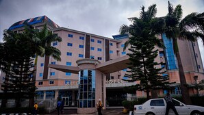 A hotel with a central entrance, multiple floors, and a distinctive blue and red striped roof.