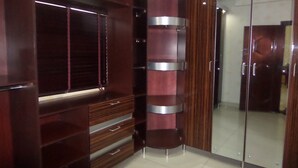 A corner closet with built-in shelves and a mirrored closet door.