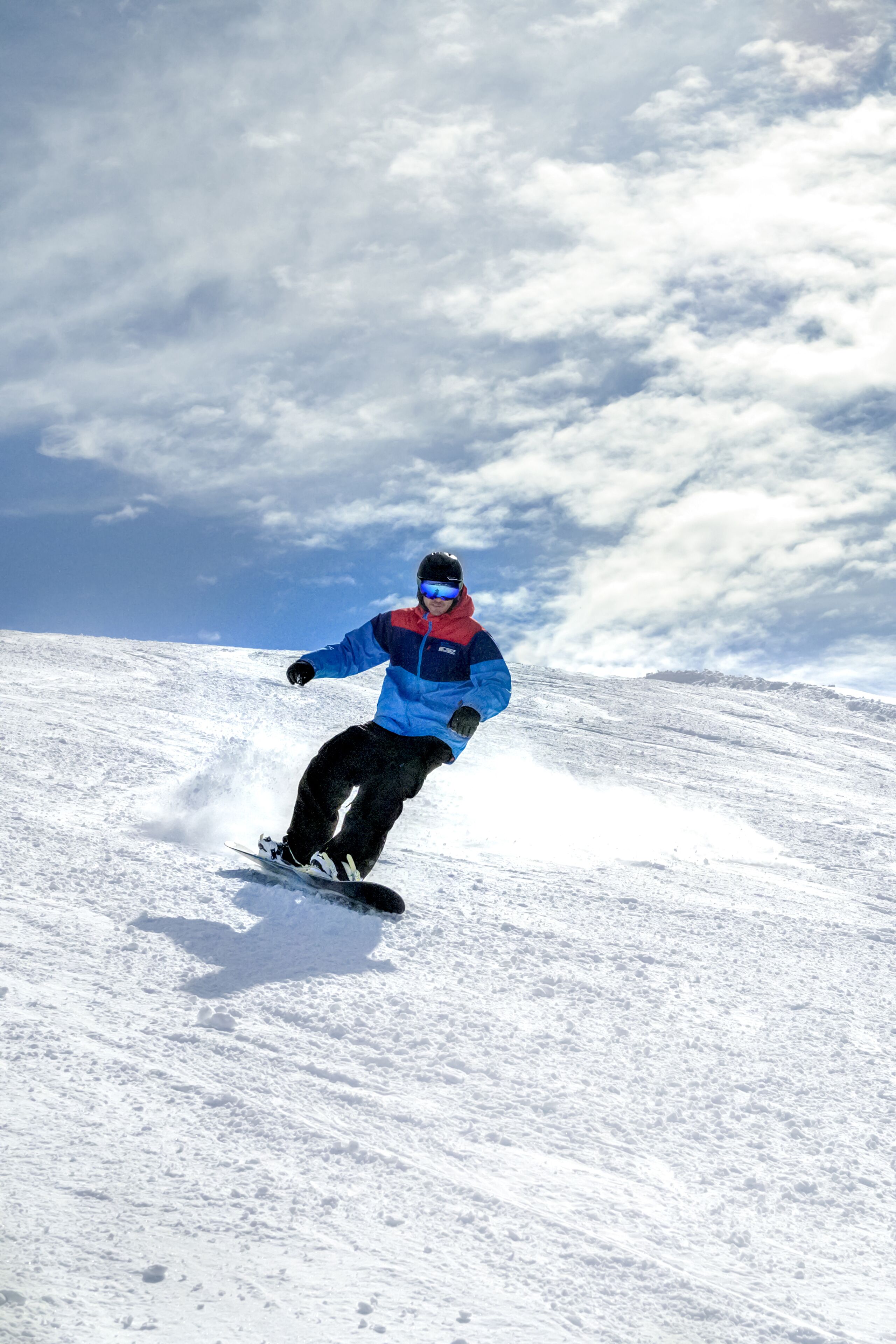 Una persona che scia da snowboard su un pendio innevato.