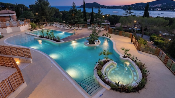 A pool area with lounge chairs, a hot tub, and a view of the sea. - Village Club Les Mas de L'Esterel (Saint-Raphael)