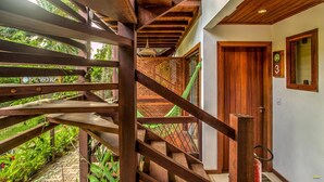 Un escalier en bois offrant une vue sur un jardin luxuriant.