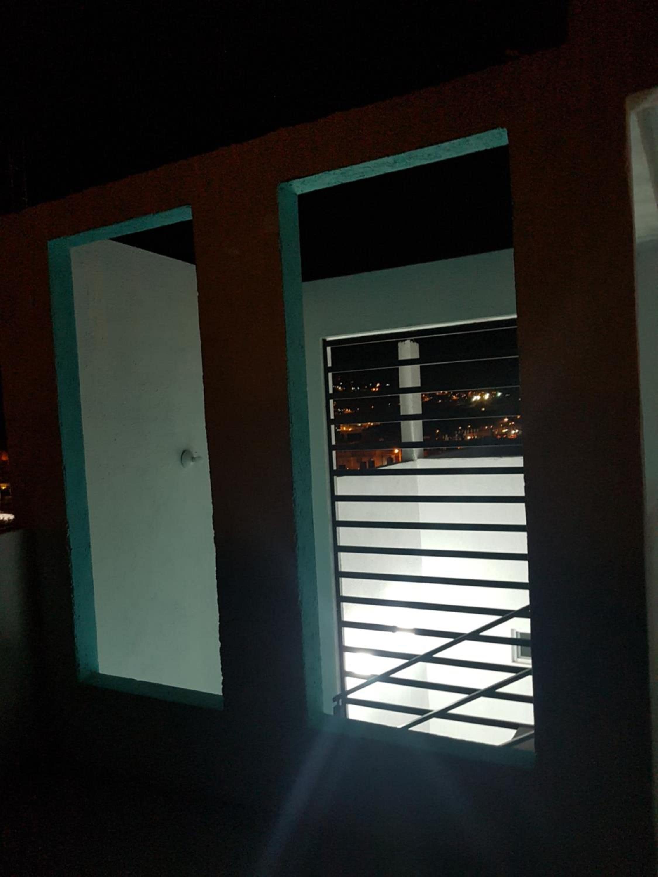 Una habitación con una puerta y una ventana con persianas horizontales.
