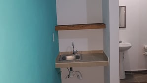 Baño con lavamanos, espejo e inodoro.