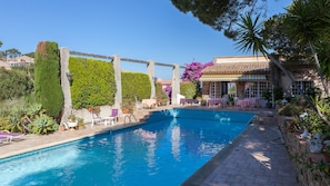 Alberca al aire libre, sombrillas en la alberca y camastros