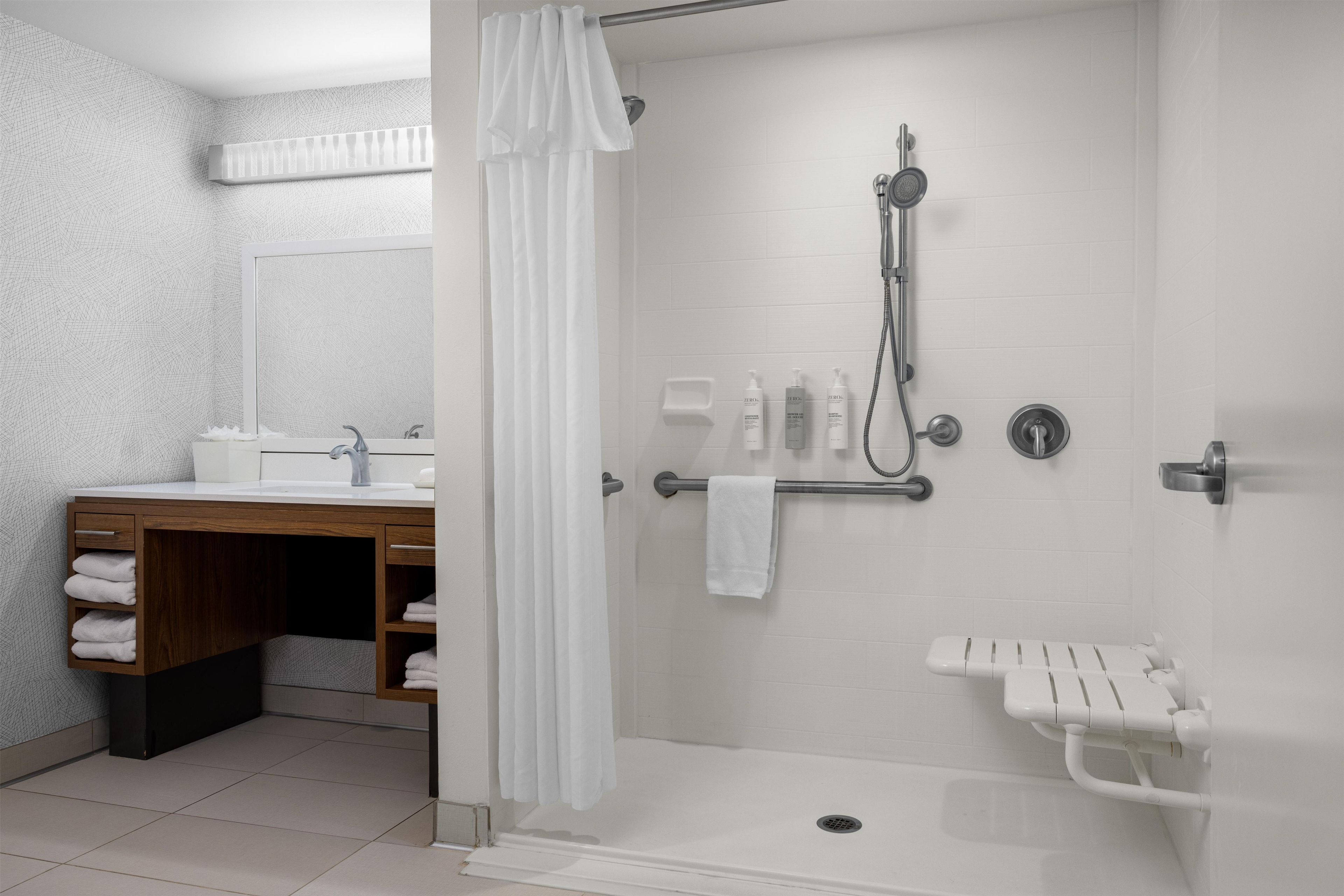 A modern bathroom with a shower, a sink, and a vanity.