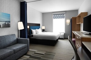 A hotel room with a bed, a desk, a television, and a window. - Home2 Suites by Hilton Minneapolis-Eden Prairie (Minnetonka)