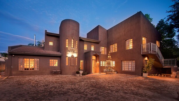 Een groot, modern huis met veel ramen en een ruime voortuin.