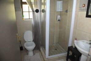 Un baño con inodoro, ducha y lavamanos.