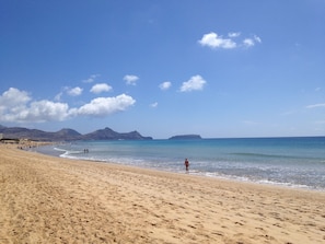 A wide sandy beach with clear blue water and distant mountains. - VILAS ESPÍRITO SANTO by brugrani (Porto Santo)