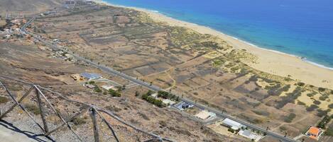 Una carretera costera con edificios y una playa.