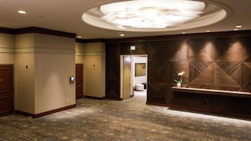 Pasillo de hotel con alfombra estampada, una recepción y un diseño de techo moderno.