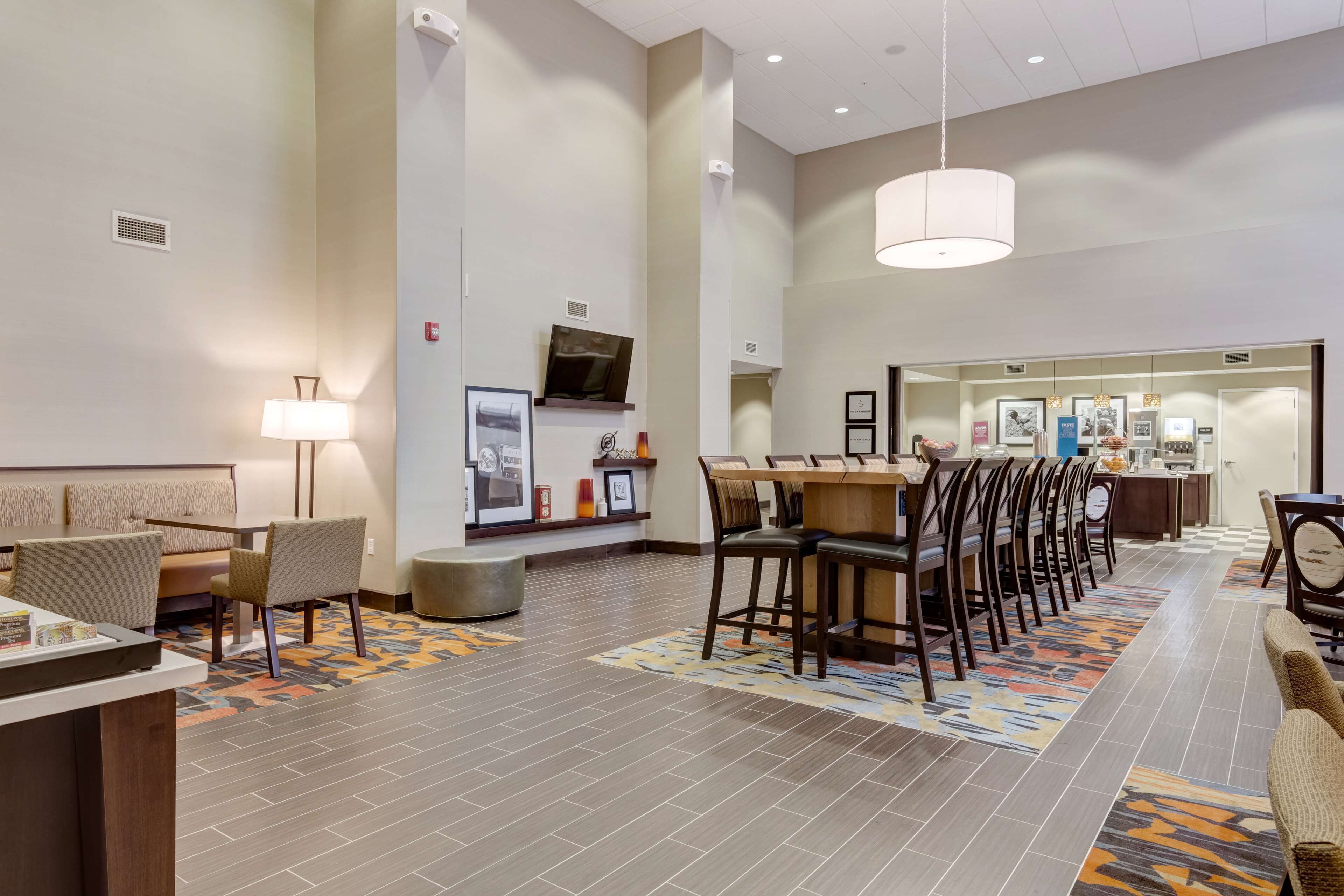 A hotel lobby with a reception desk, seating area, and a dining section.