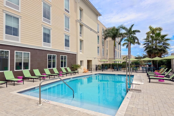 Alberca al aire libre, sombrillas en la alberca y camastros 