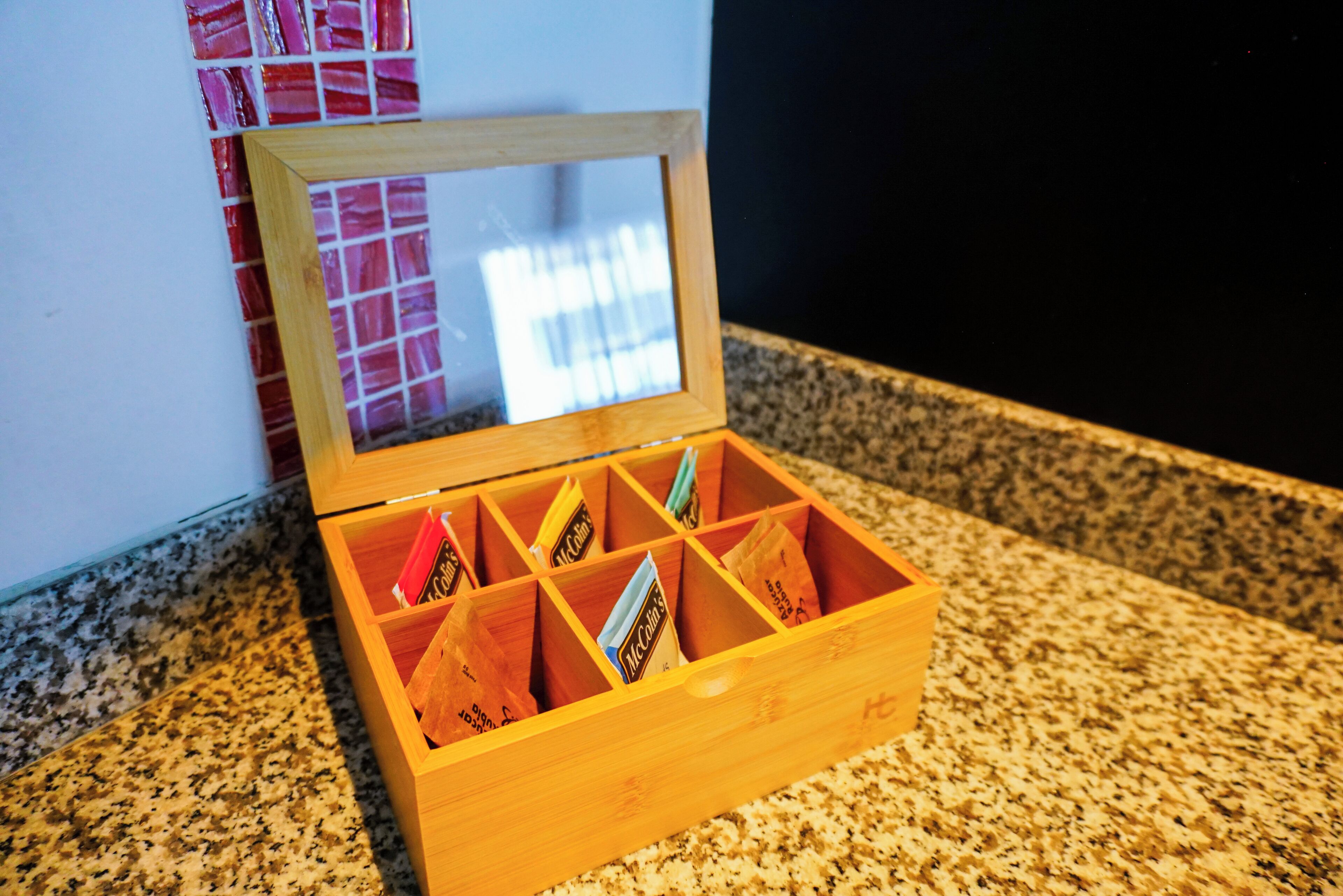 A wooden box with compartments containing various items.