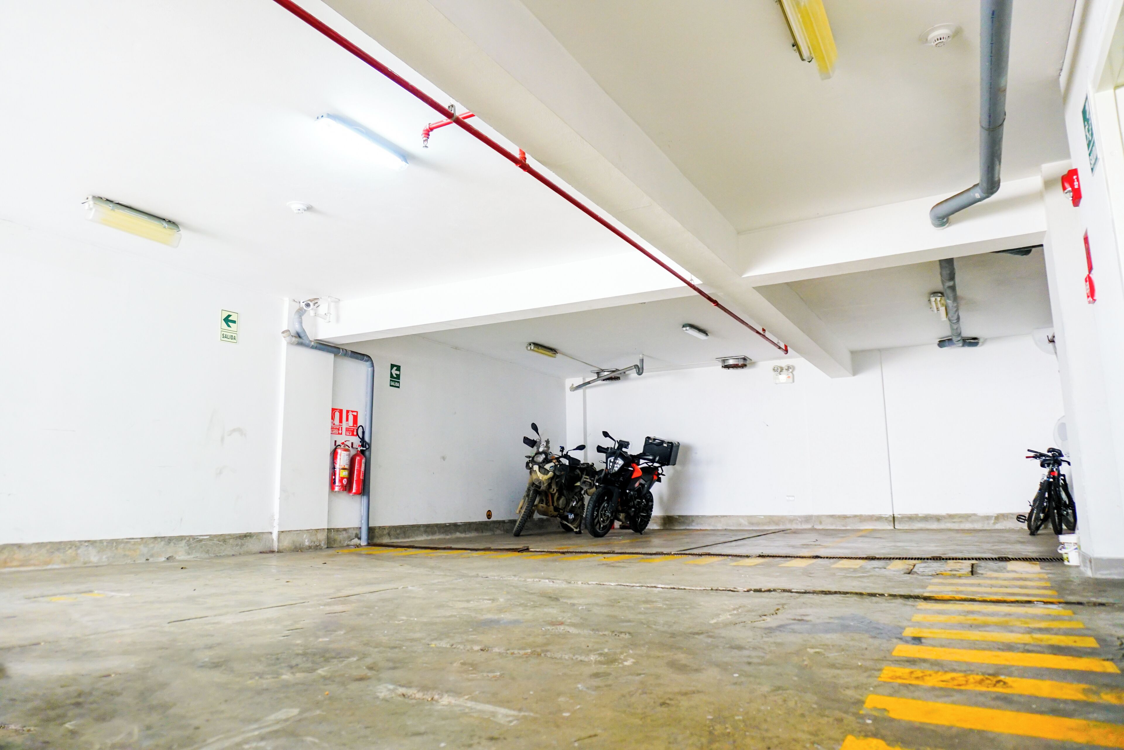 A clean, well-lit indoor parking area with concrete floors and yellow safety lines.