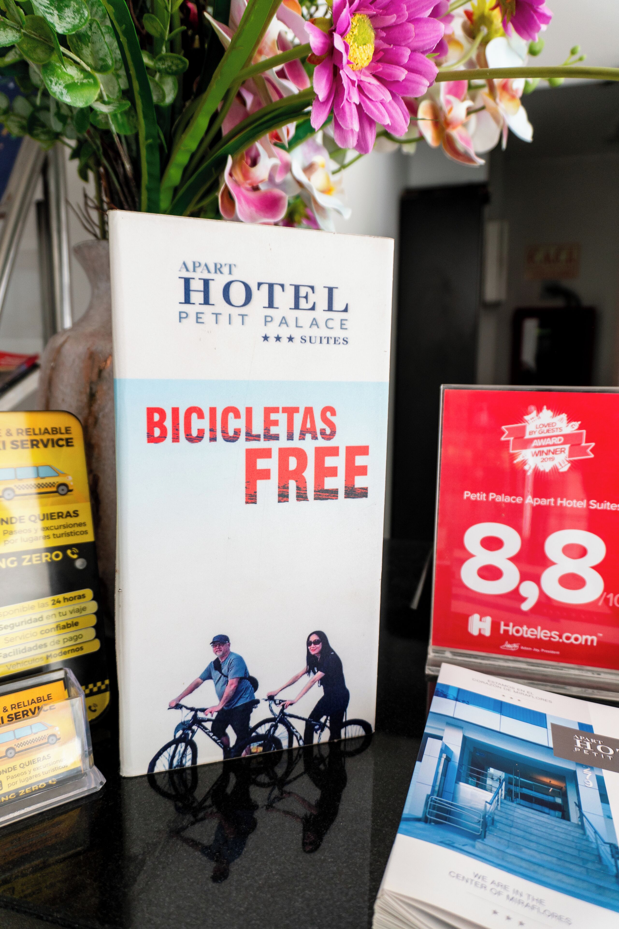 Promotiemateriaal voor Petit Palace Apart Hotel Suites, met aandacht voor gratis fietsverhuur en een beoordeling van 8,8/10 van Hotels.com.