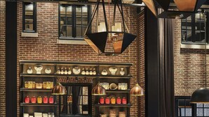 A restaurant interior with brick walls, wooden tables, and hanging pendant lights. - Pendry Baltimore (Baltimore)