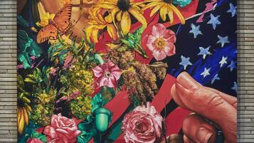 A mural with a person's face, vibrant flowers, and an American flag.