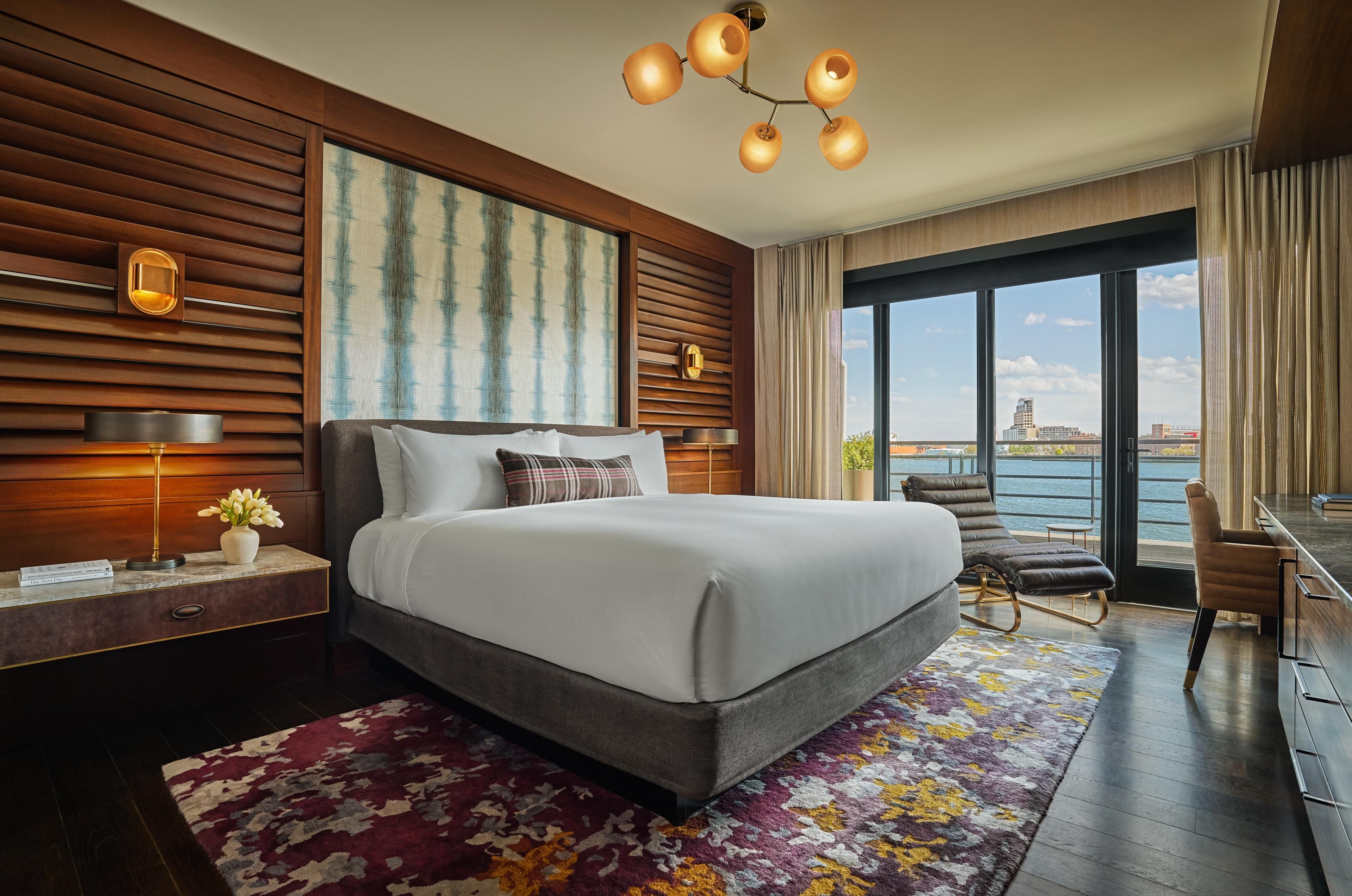 Habitación de hotel moderna con una cama grande, un escritorio y vistas a la ciudad.
