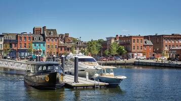 A waterfront with boats docked at a pier, surrounded by colorful buildings.