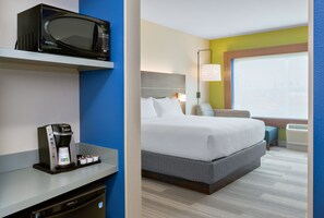 Une chambre d’hôtel équipée d’un lit, d’un four à micro-ondes, d’une machine à café et d’une fenêtre donnant sur un paysage agréable.