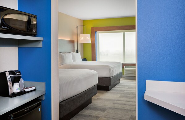 Une chambre d’hôtel avec deux lits, un four à micro-ondes, une machine à café et une fenêtre donnant sur un beau paysage.