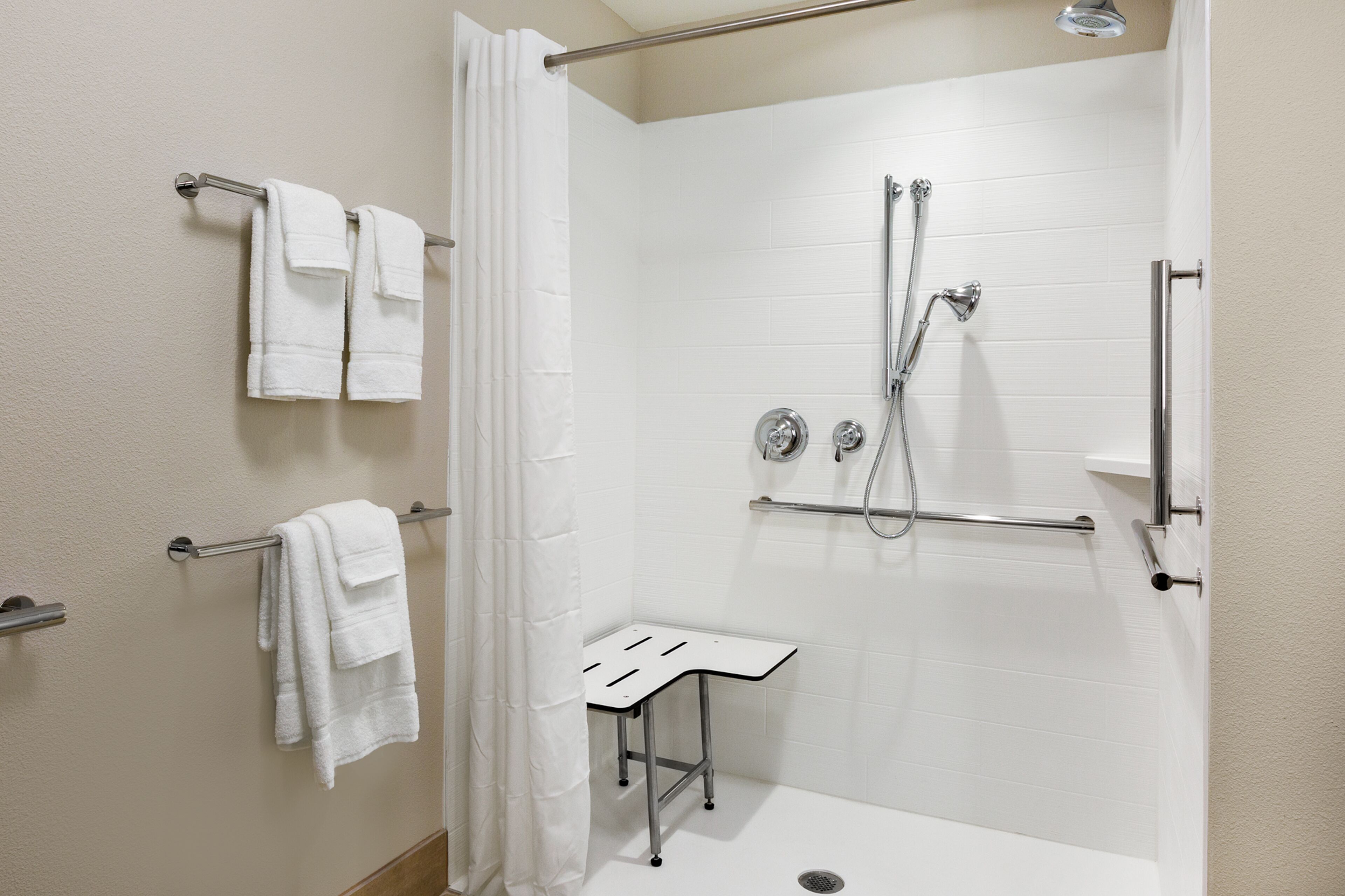 A modern shower area with a glass door, a handheld showerhead, and a handheld shower attachment.