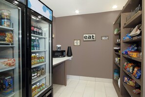 A kitchenette area with a refrigerator stocked with beverages, a microwave, and a coffee maker.