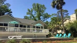 A house with a covered porch, outdoor seating, and a small garden area with chairs. - Palmetto Paradise 3 Bedroom Holiday Home (Hilton Head Island)