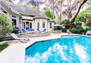 A swimming pool with lounge chairs and a patio area.