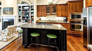 A modern kitchen with wooden cabinets, a granite countertop, and stainless steel appliances. - Su Casa 5 Bedroom Holiday Home (Hilton Head Island)