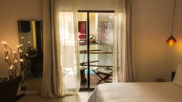 Un dormitorio con una cama, una silla y vistas a un espacio exterior con una mesa y sillas.