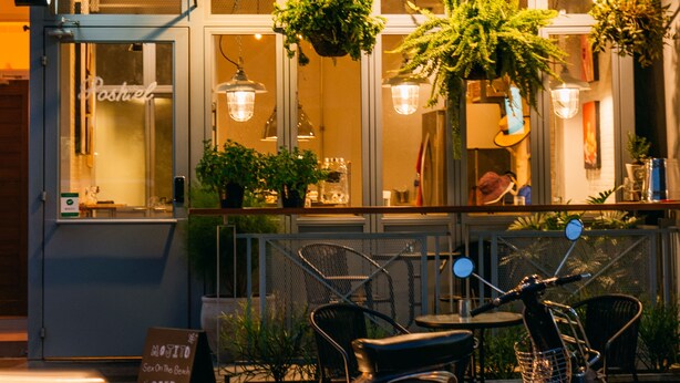 A restaurant named 'POSHTEL' with outdoor seating and a scooter parked in front. - J Poshtel Chiangmai (Chiang Mai)