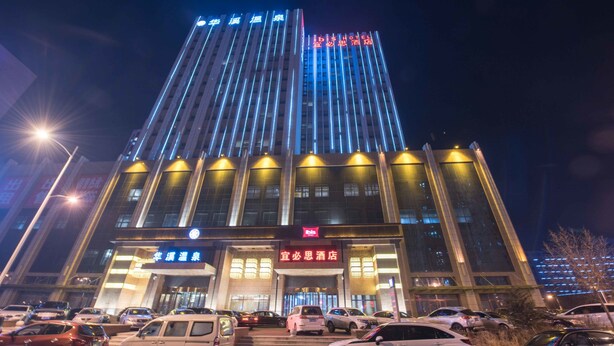 A hotel with a modern facade, multiple floors, and illuminated signage. - ibis Daqing Haofang (Daqing)