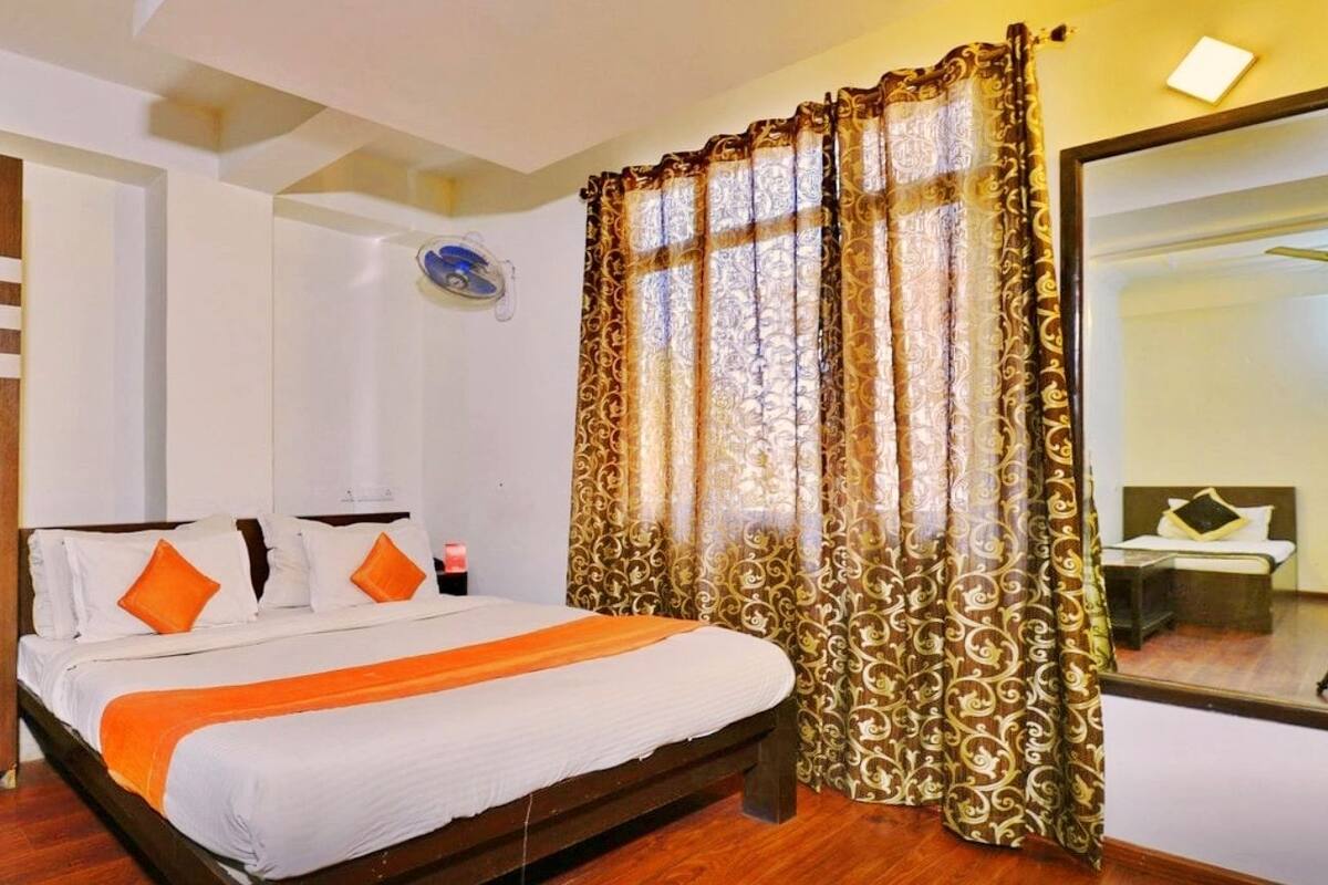 Un dormitorio con cama, armario y cortinas.