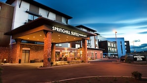 Un hôtel doté d’une entrée couverte, d’une enseigne indiquant « Springhill Suites Marriott » et d’un espace de stationnement.