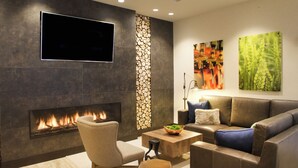 Un salon moderne avec une cheminée, un téléviseur à écran plat, un canapé et une table basse.