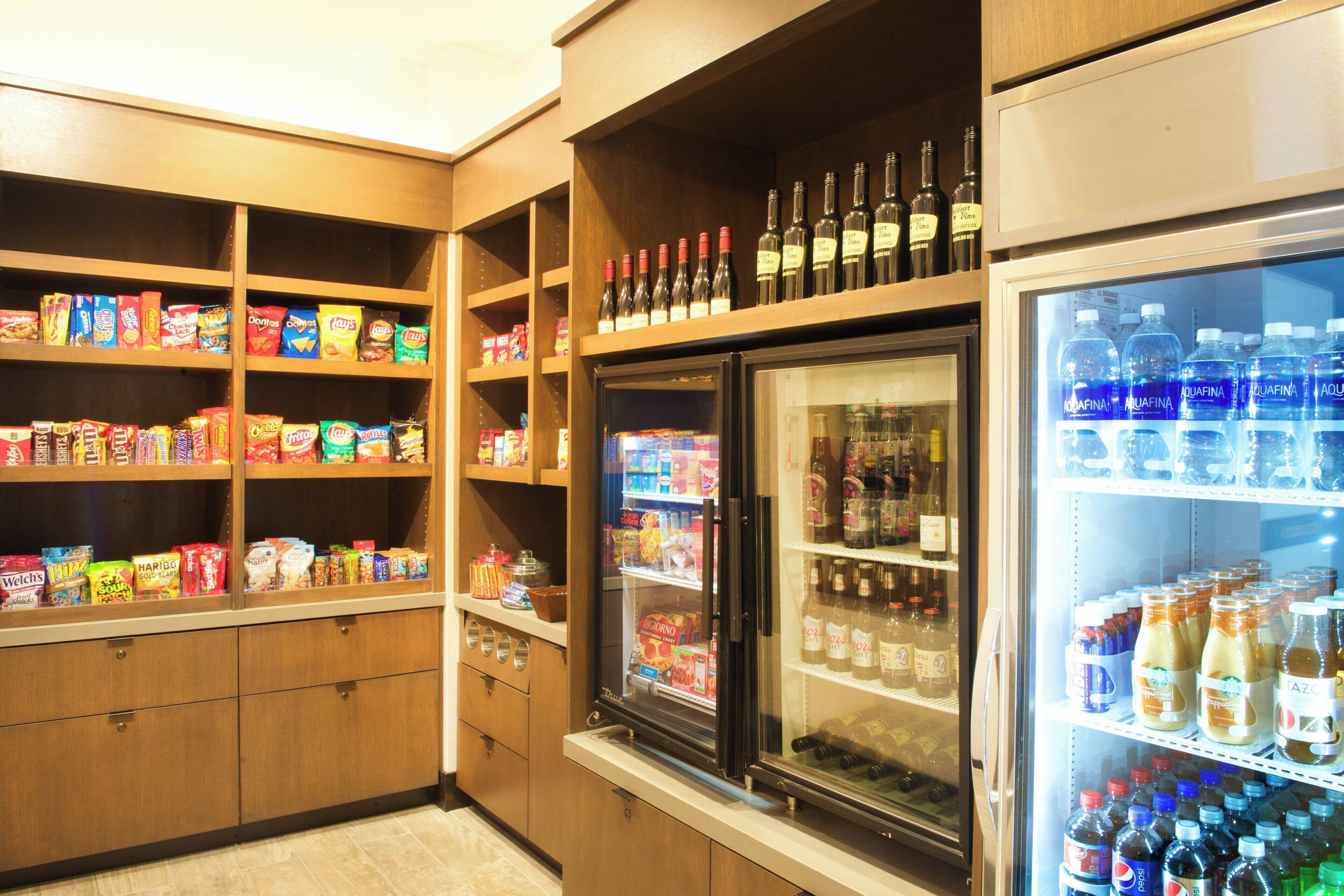 Un refrigerador bien surtido con aperitivos y bebidas, que incluye varias opciones de bocadillos y bebidas embotelladas.