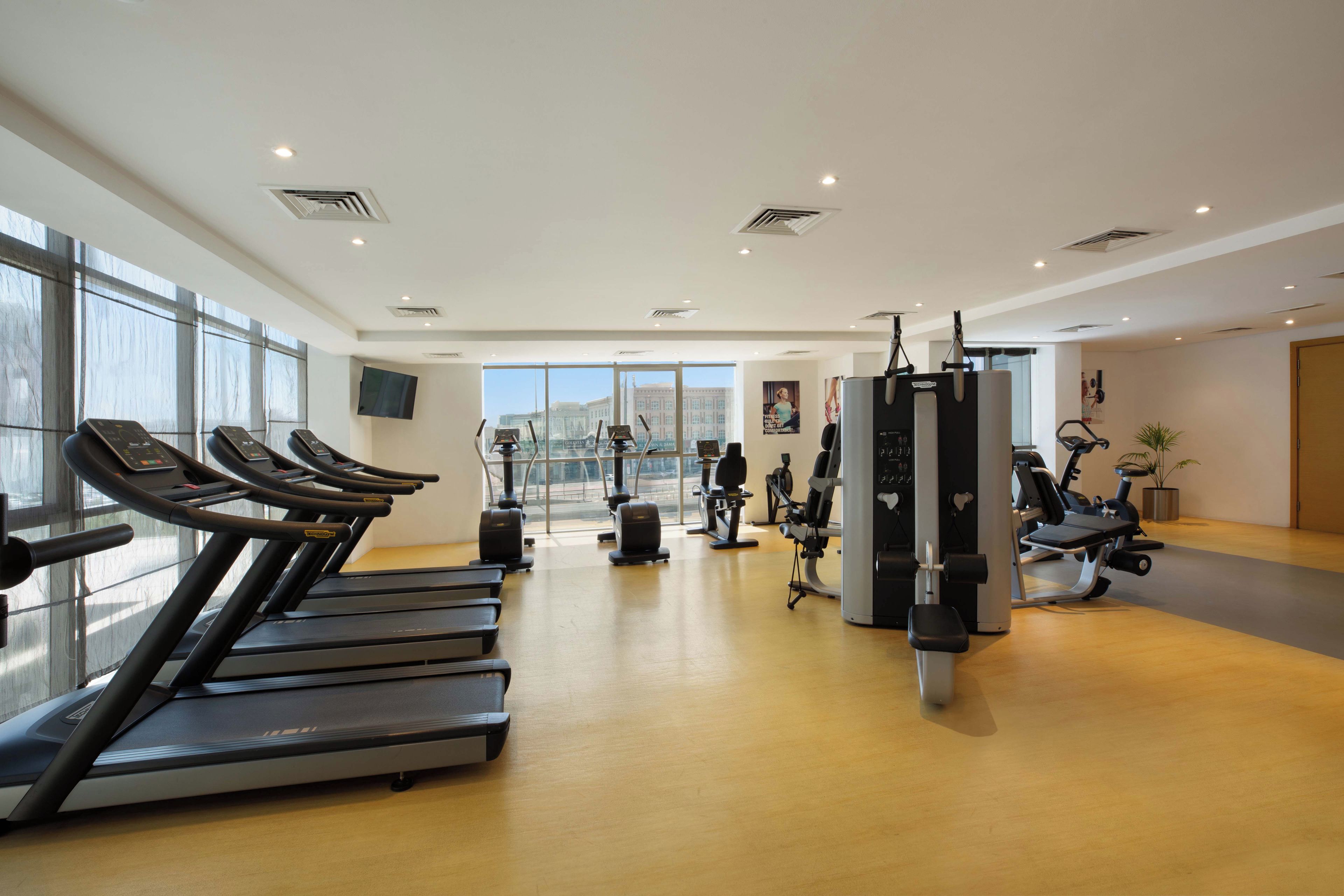 Una palestra con tapis roulant, cyclette e macchinari per l'allenamento con i pesi.