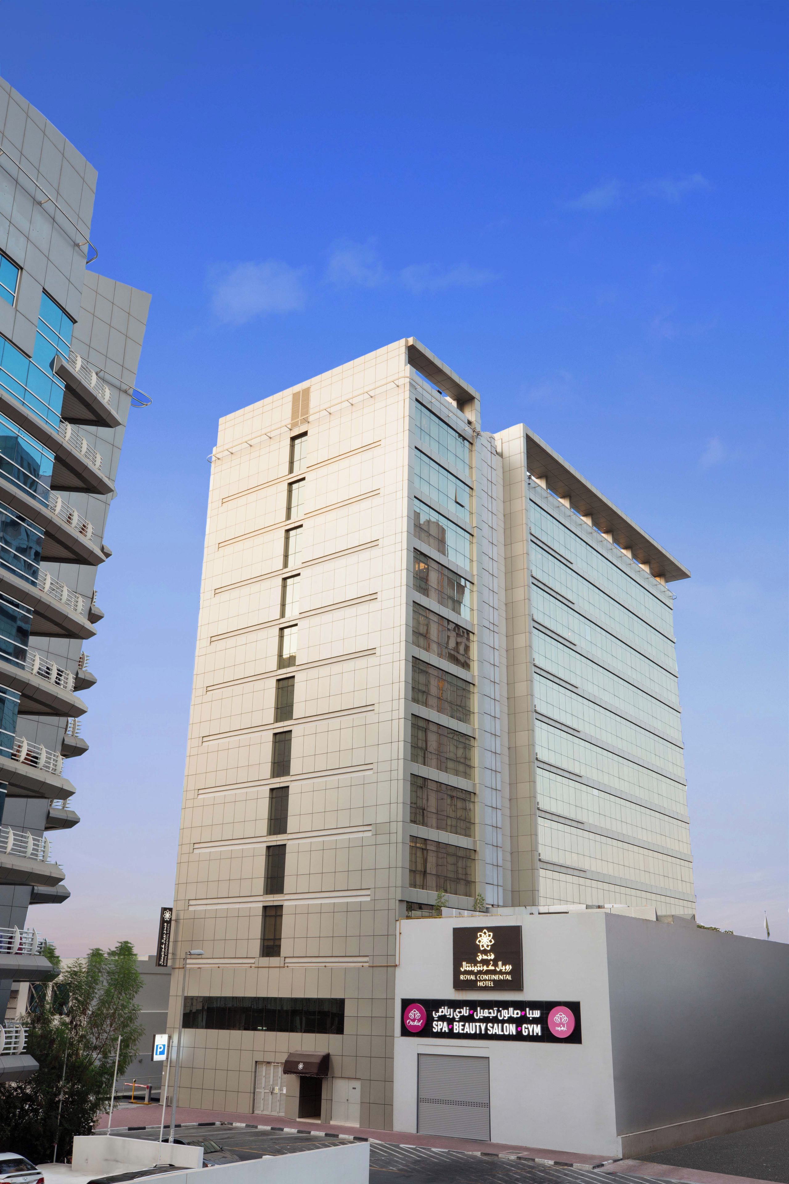 Un hôtel à plusieurs étages, reconnaissable à son enseigne bien visible indiquant « Royal Continental Hotel ».