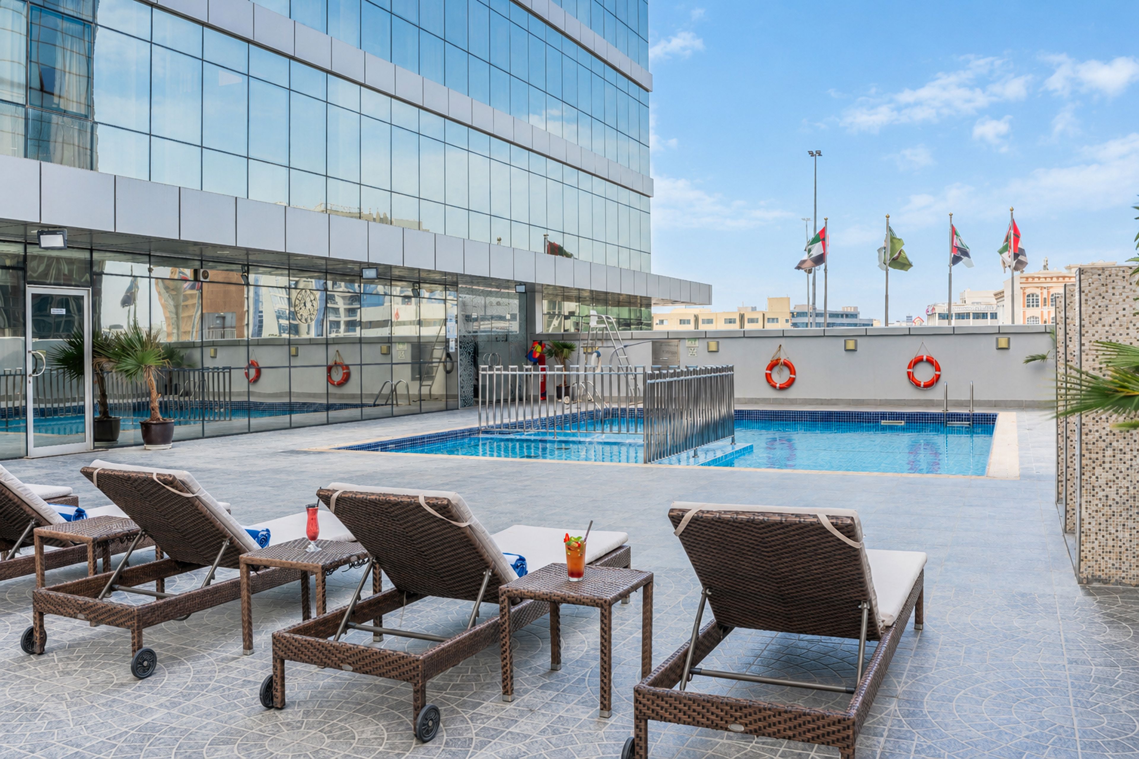 A rooftop pool area with lounge chairs and a swimming pool.