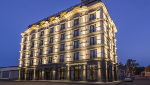 Un hôtel à plusieurs étages, doté d’une architecture classique, avec des balcons et de grandes fenêtres.