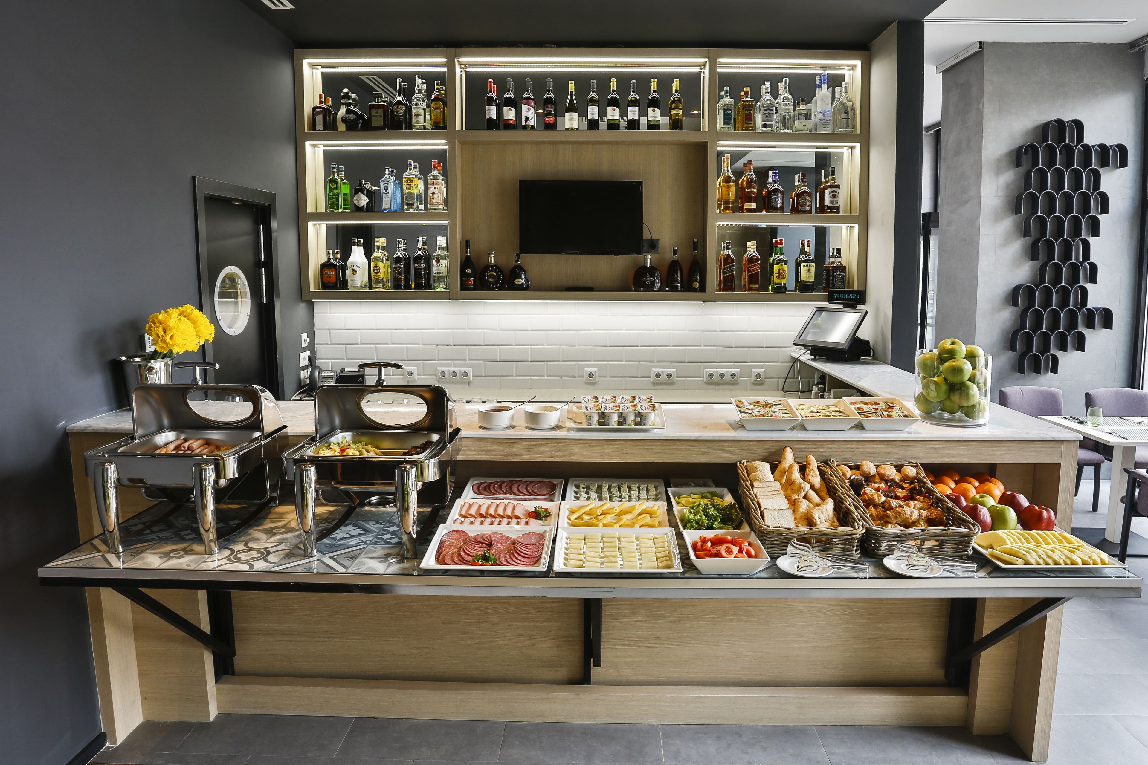 Un mostrador de buffet con diferentes opciones de comida y una variedad de botellas de licor.