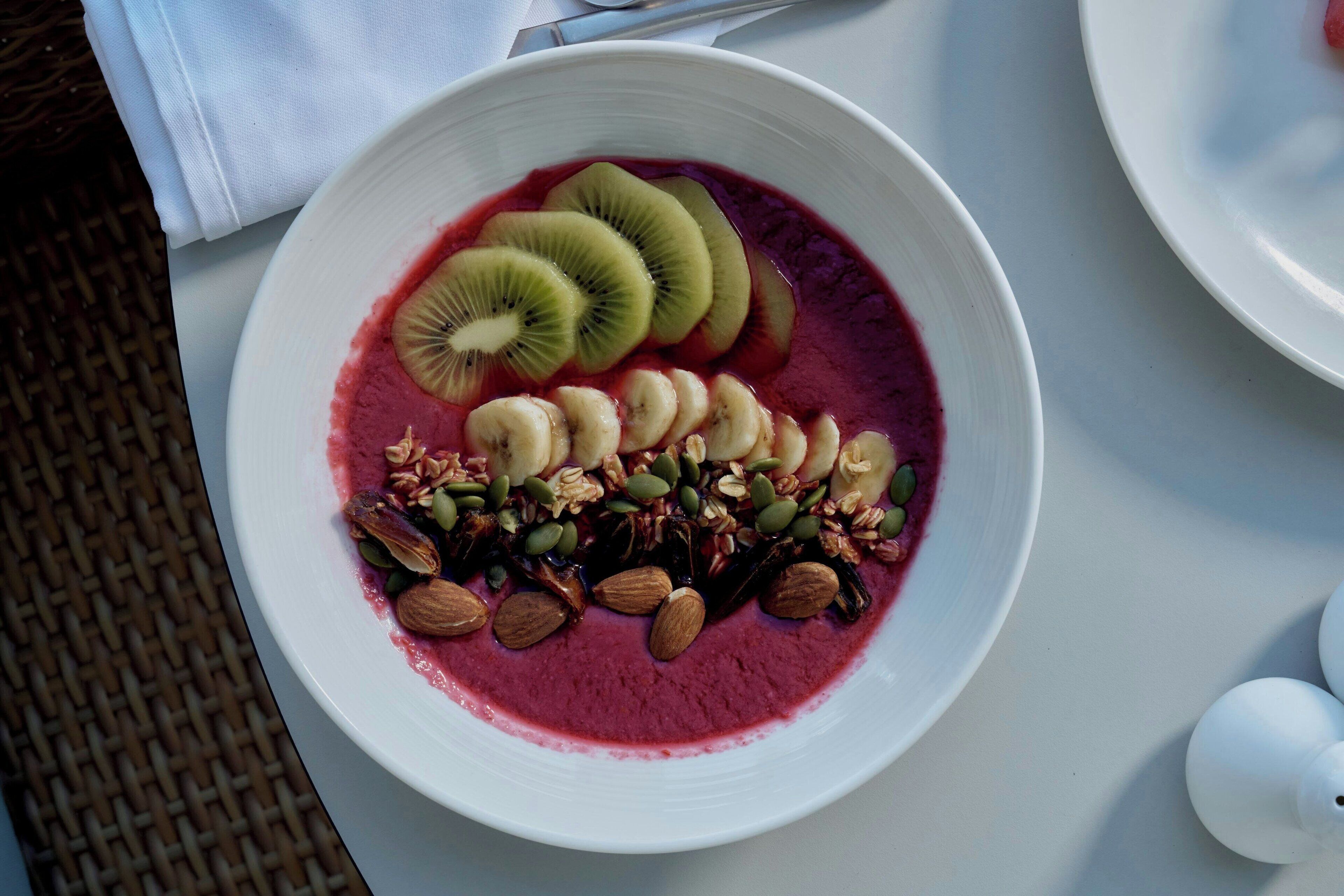 Un tazón de batido con frutas y nueces.