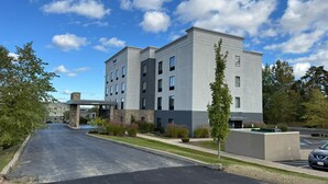 A modern hotel with a covered entrance, multiple floors, and a parking area. - Spark by Hilton Erie (Erie)