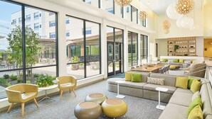 A spacious lobby with large windows, a seating area with sofas and chairs, and a central coffee table. - Element by Marriott West Des Moines (West Des Moines)