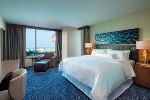 A hotel room with a large bed, a desk, a chair, and a view of the city. - The Westin Milwaukee (Milwaukee)